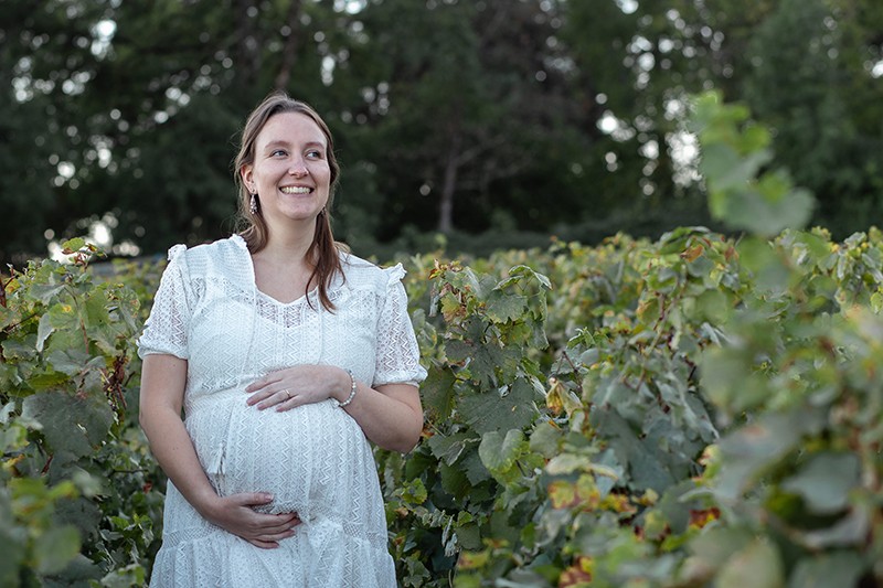 Photographe-Dijon-grossesse-maman-sourit-dans-vignes