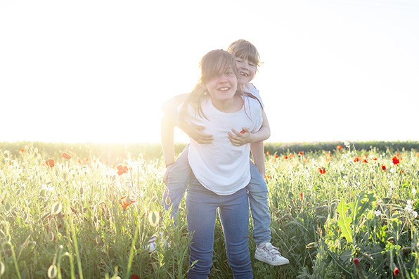Photographe famille dijon deux soeurs s amusent dans un champ de coquelicots